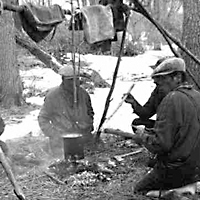Indian trappers taking a noon break, boiling muskrat for lunch